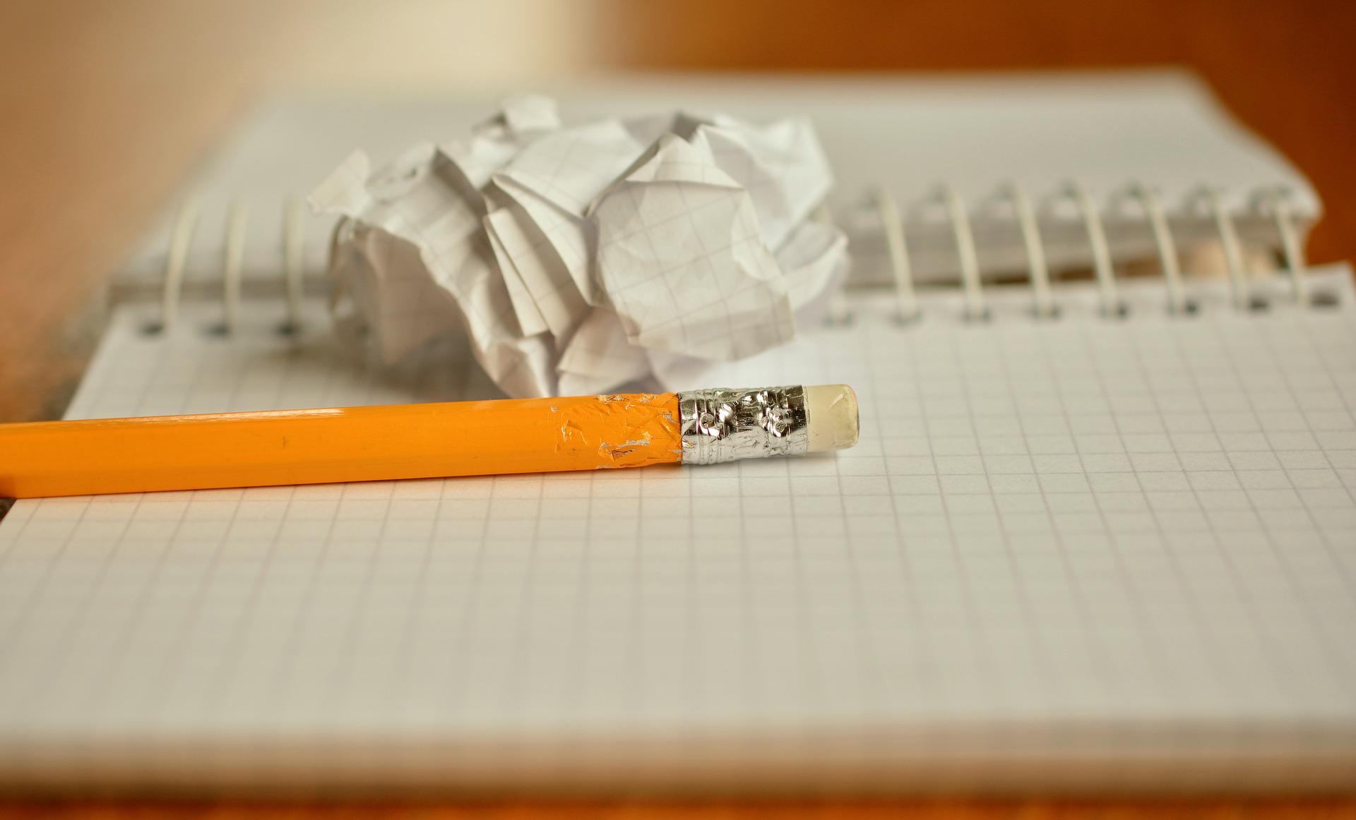 Un crayon à papier et une feuille froissée sur un cahier